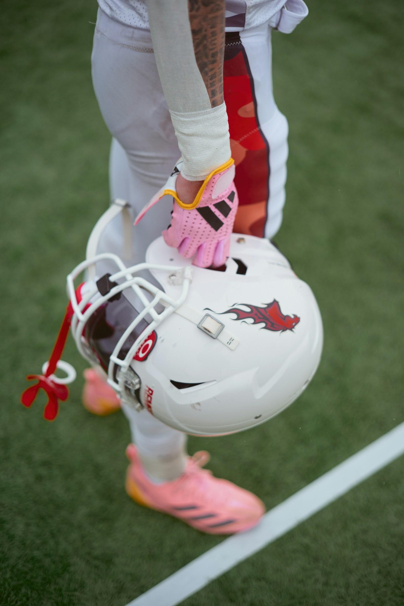 An American football player holding a helmet — illustrative archive photograph
